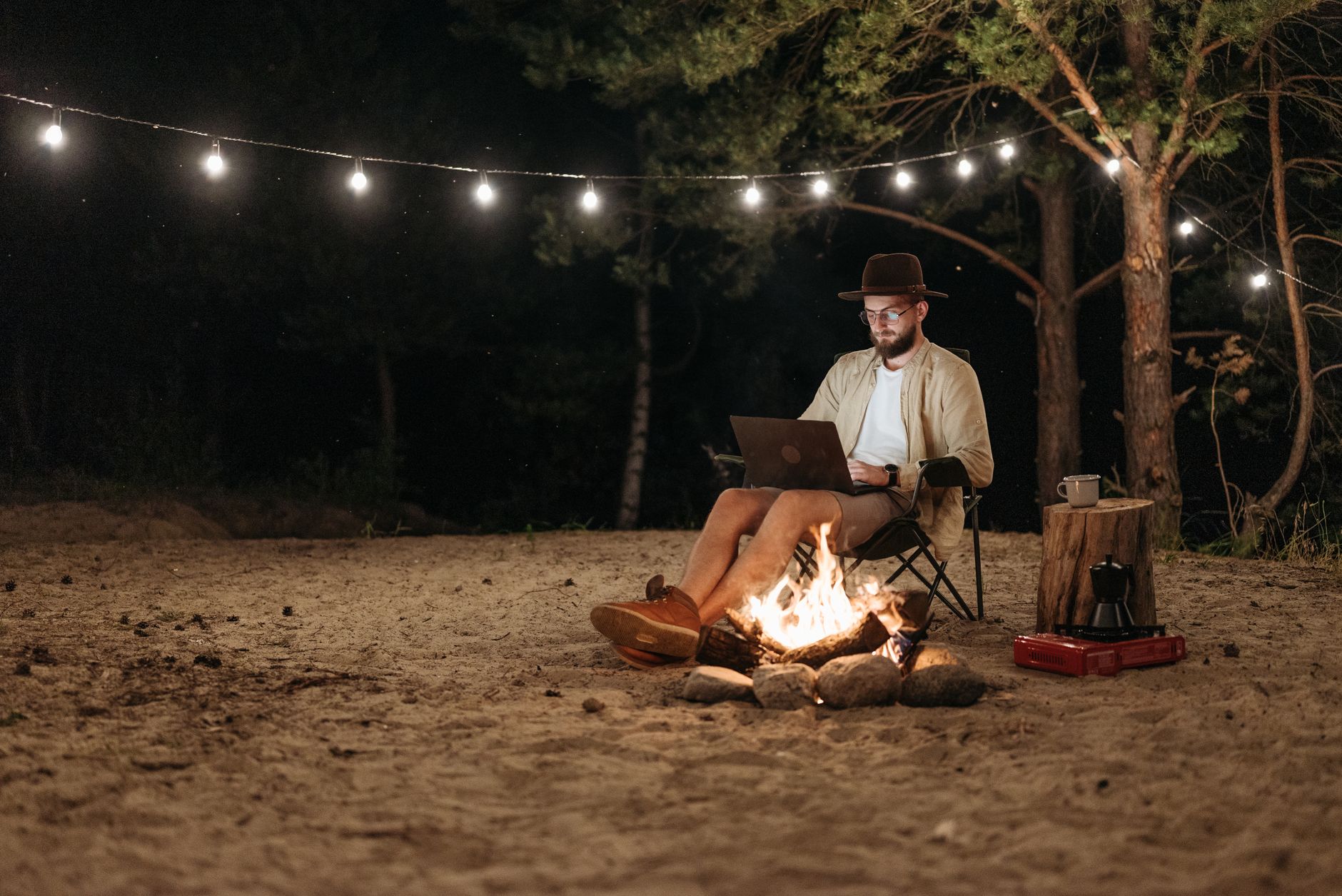 Une personne travaille sur son ordinateur portable en pleine nature, en toute autonomie de lieu et d'horaires.